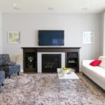 TV Hanging Above Fireplace In Modern Living Room