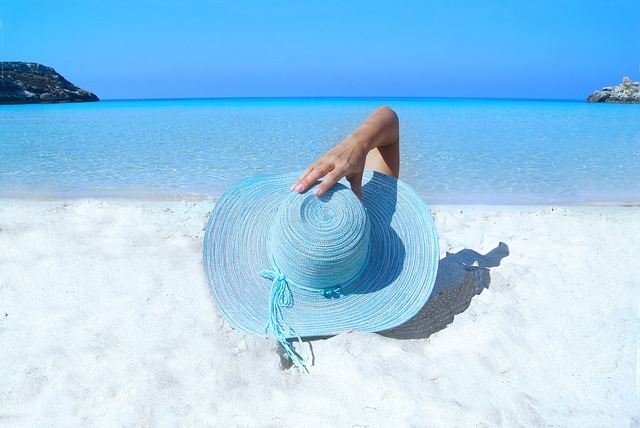 Women lying on the beach with blue hat