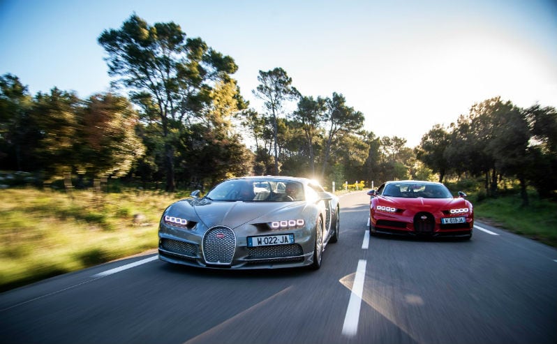 Silver Bugatti and Red Bugatti On The Road Racing