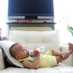 Adorable Asian Baby on Couch Drinking Baby Formula